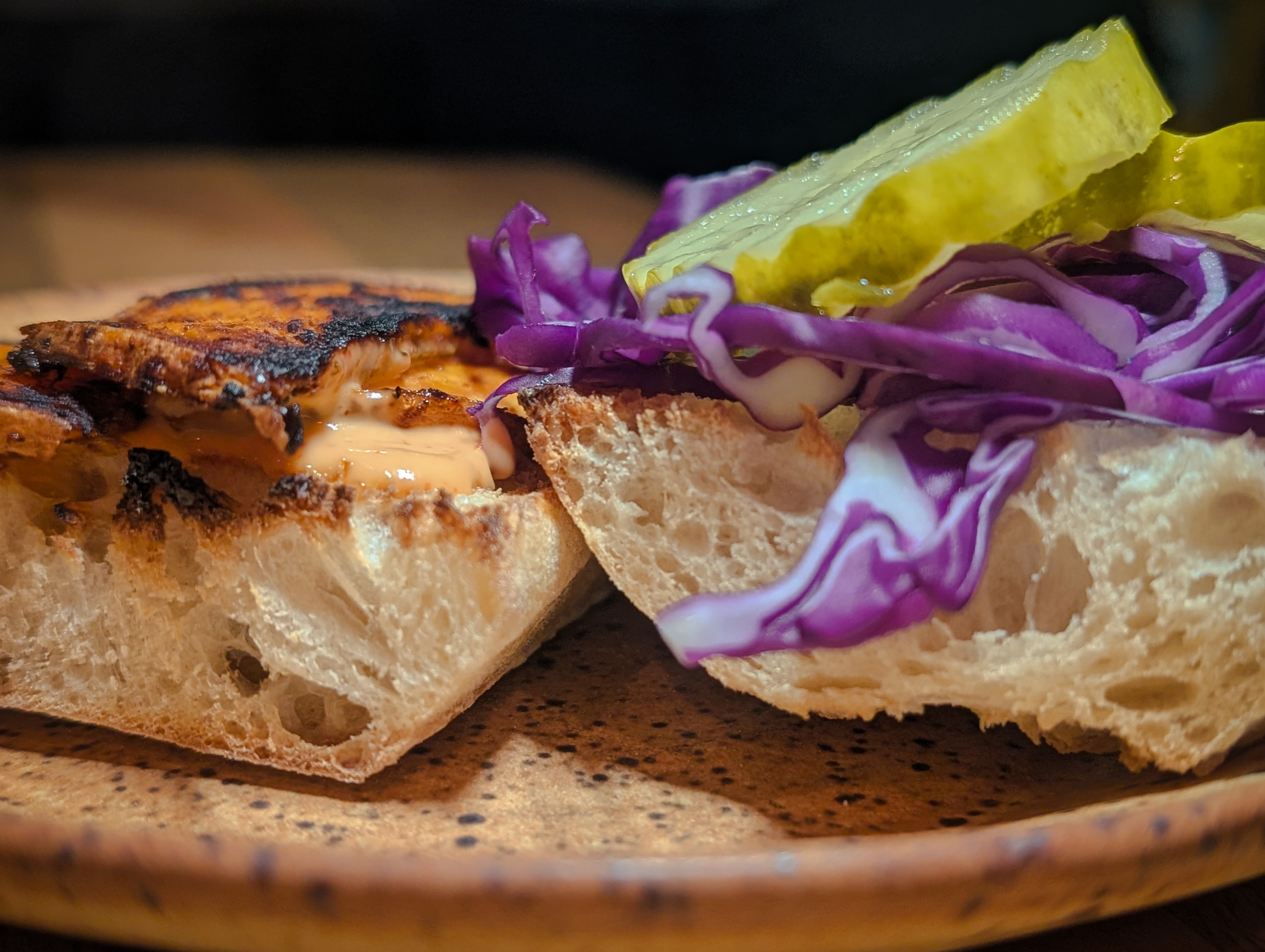 Side view of an open sweet potato pickle cabbage sandwich on a plate.